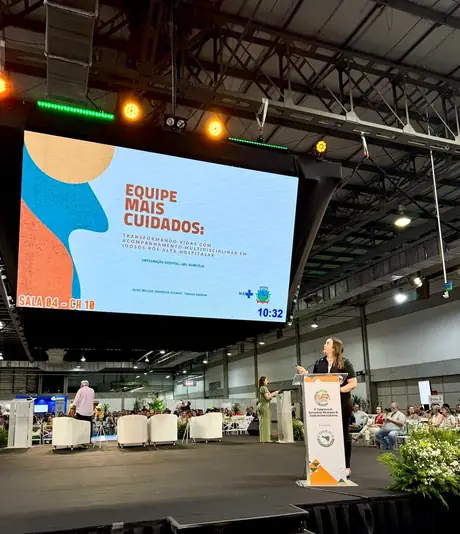 Andressa Schmidt no palco apresentando o projeto Equipe Mais Cuidados